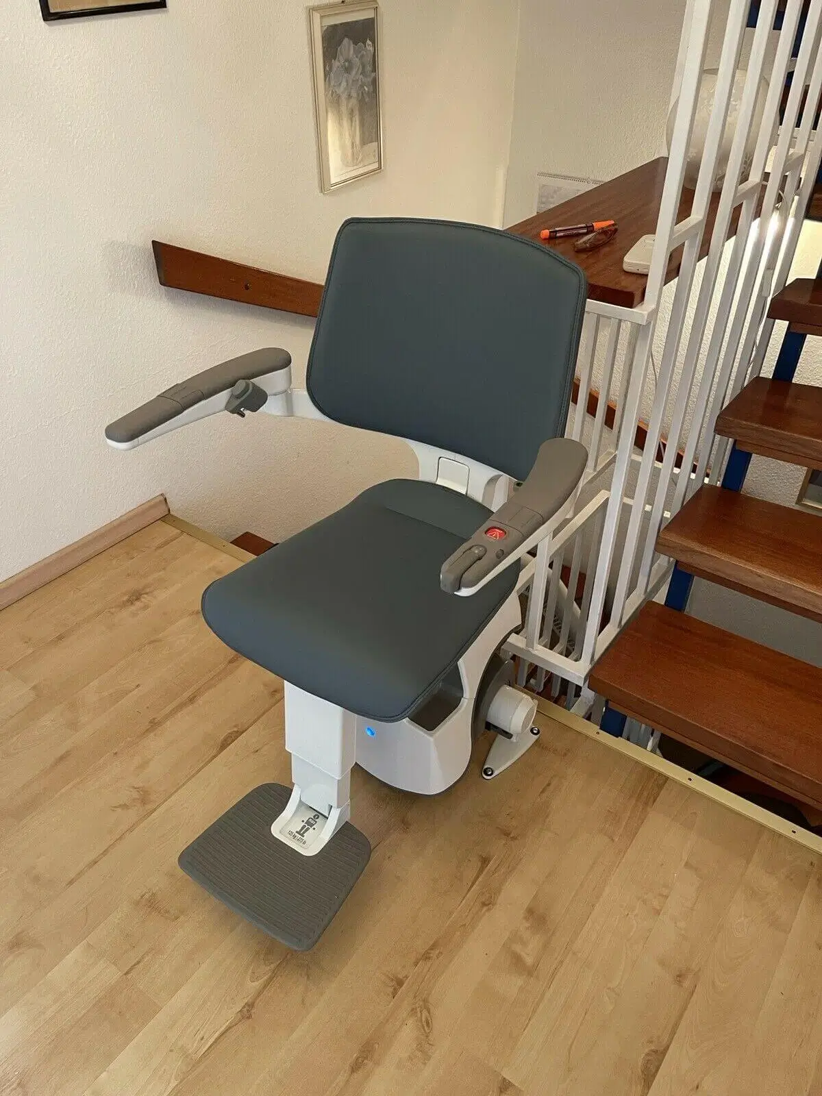 Gray upholstered seat lift showing armrests and footrest in Shidler