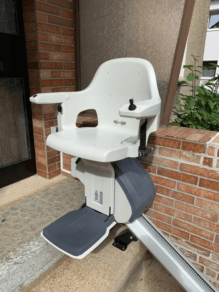 Weatherproof outdoor stairlift with folding plastic seat at entryway in Shidler