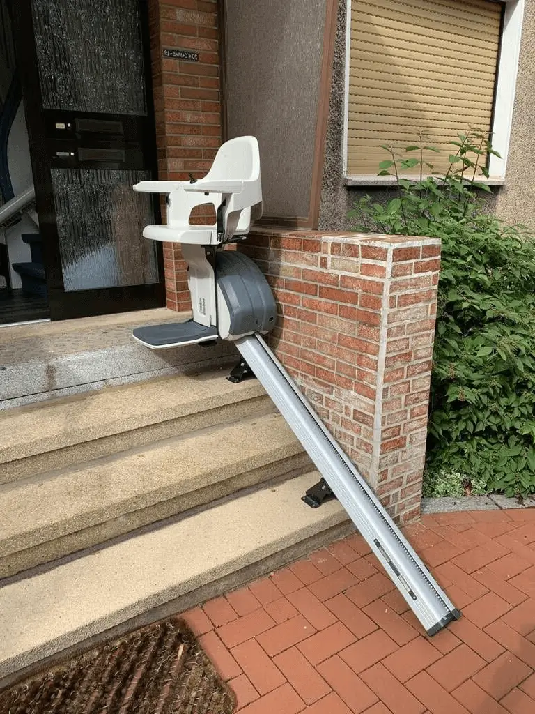 Outdoor stairlift on narrow straight rail at entry steps in Shidler