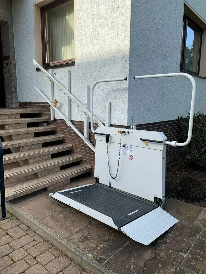 Wheelchair platform lift in folded position at entry steps in Shidler