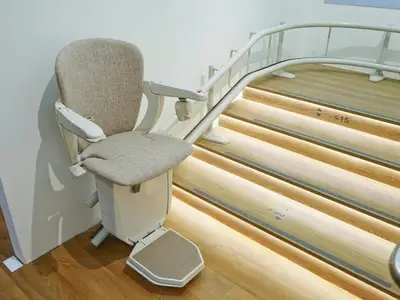Beige stairlift seat on illuminated staircase in Baxter, MN.