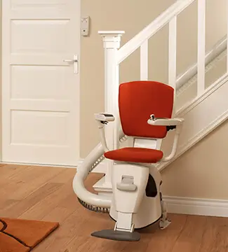 White-and-red narrow stairlift installed on a tight indoor staircase in Beaver Creek, MT.
