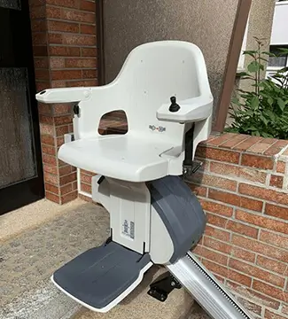 White weatherproof stairlift on outdoor stone staircase in Myton.